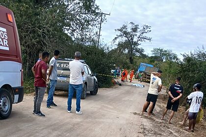 Carros e pessoas em uma estrada de barro após um acidente