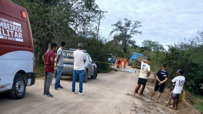 Carros e pessoas em uma estrada de barro após um acidente