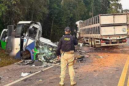 Policial rodoviário federal diante de um carro destruído