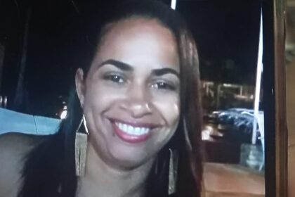 Mulher sorrindo aparentando estar feliz em um local durante a noite