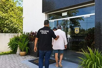 Homem sendo conduzido pra delegacia