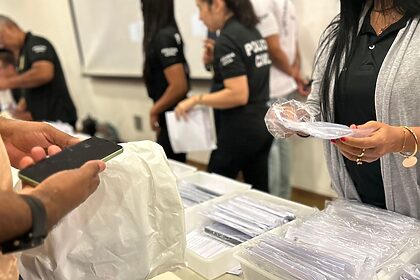 Policiais contabilizando os celulares recuperados
