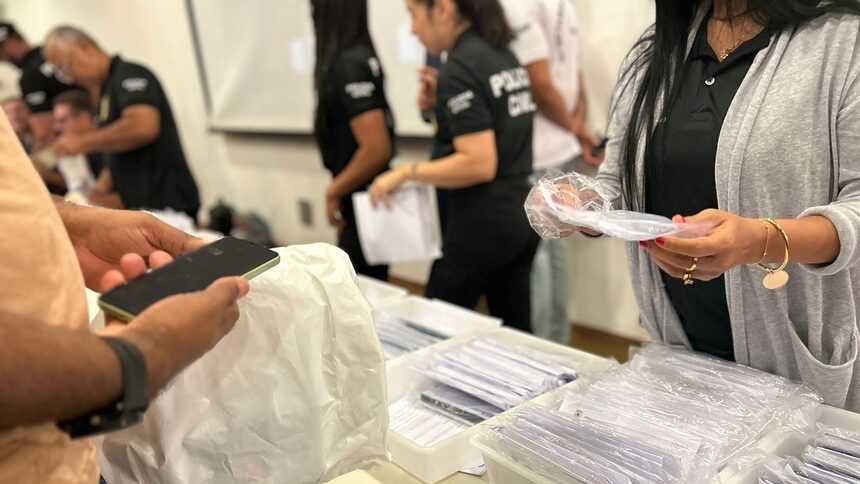 Policiais contabilizando os celulares recuperados